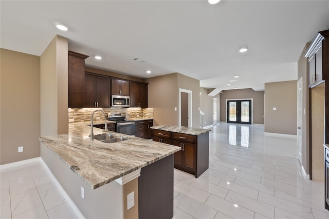 kitchen featuring sink, light stone counters, tasteful backsplash, light tile patterned floors, and stainless steel appliances