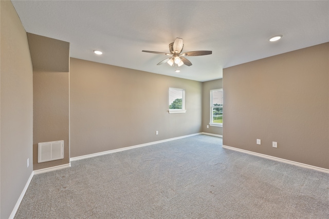 carpeted spare room with ceiling fan