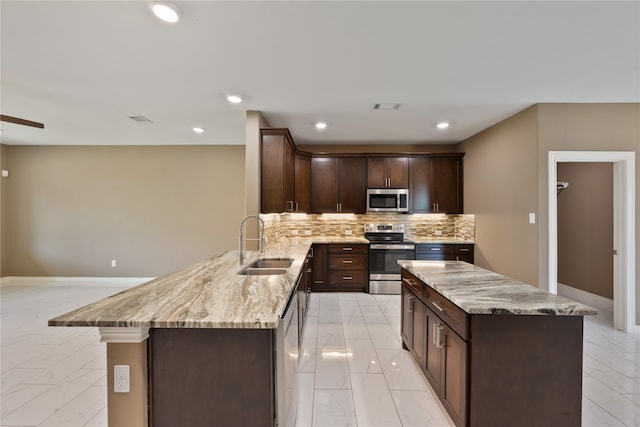 kitchen featuring tasteful backsplash, light tile patterned floors, sink, kitchen peninsula, and stainless steel appliances