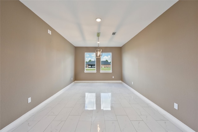 tiled empty room featuring a notable chandelier