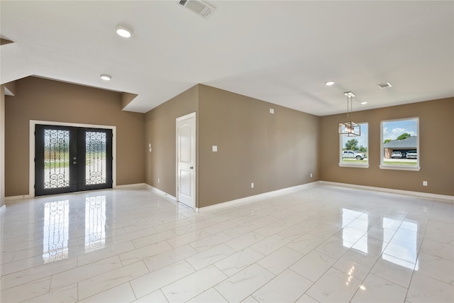 unfurnished room featuring plenty of natural light, light tile patterned floors, and french doors