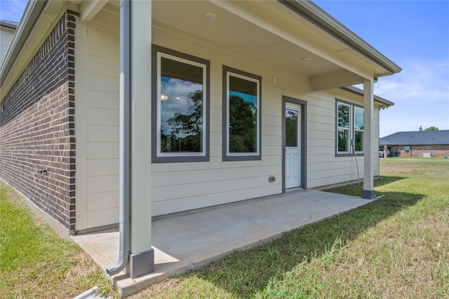 view of side of property with a patio and a yard