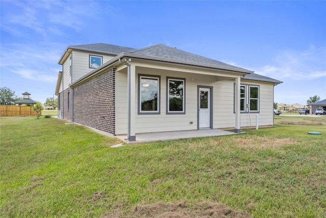 back of property with a lawn and a patio