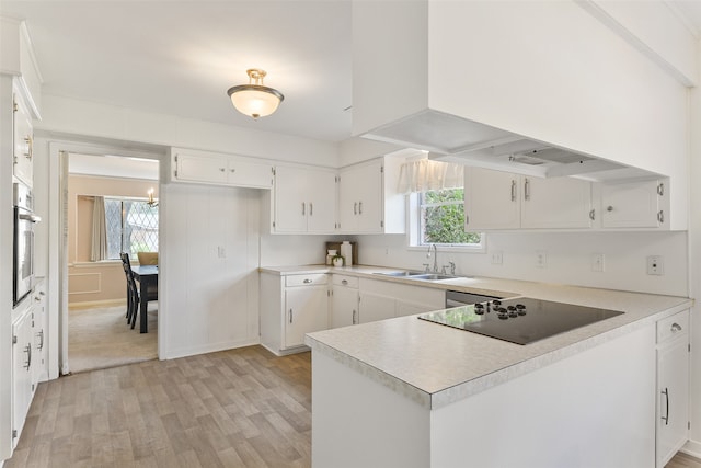 kitchen with light carpet, white cabinetry, sink, stainless steel oven, and black electric cooktop