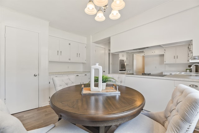 dining room featuring light hardwood / wood-style flooring, a notable chandelier, and sink