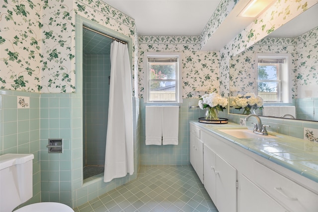 bathroom with tile patterned floors, toilet, tile walls, a shower with curtain, and vanity