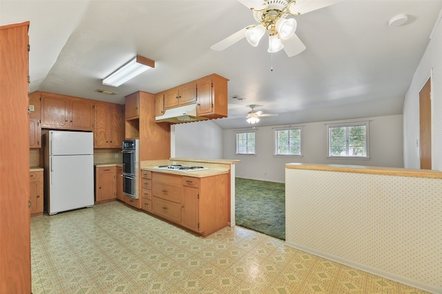 kitchen featuring gas stovetop, light carpet, white fridge, kitchen peninsula, and ceiling fan