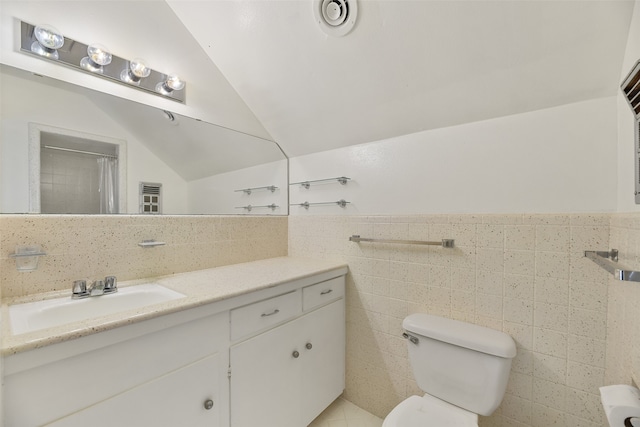 bathroom featuring backsplash, toilet, lofted ceiling, tile walls, and vanity