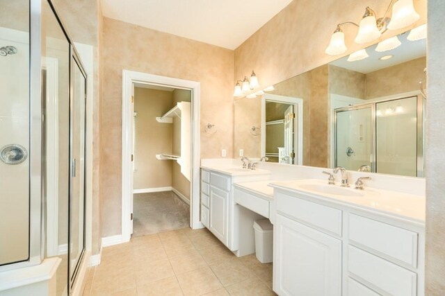 bathroom with dual vanity, an enclosed shower, and tile patterned flooring