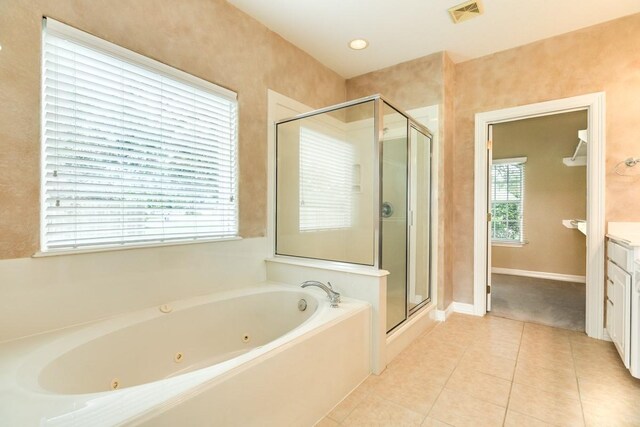 bathroom featuring plus walk in shower, vanity, and tile patterned floors