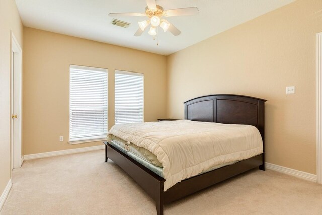 bedroom with ceiling fan, multiple windows, and light carpet