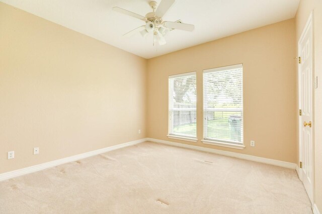 carpeted spare room with ceiling fan and a healthy amount of sunlight