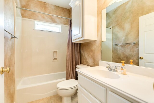 full bathroom featuring tile patterned flooring, toilet, vanity, and shower / bath combo with shower curtain