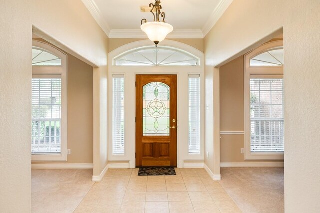 entryway with light tile patterned flooring and ornamental molding