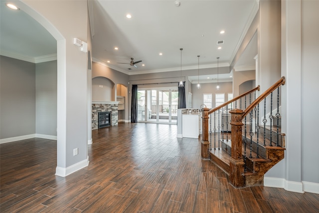 living room with a fireplace, ceiling fan, ornamental molding, and wood-type flooring