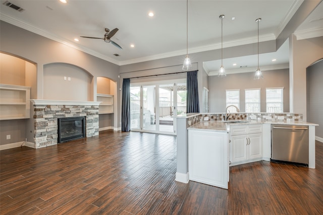 kitchen featuring stainless steel dishwasher, dark wood-type flooring, white cabinets, ceiling fan, and a stone fireplace