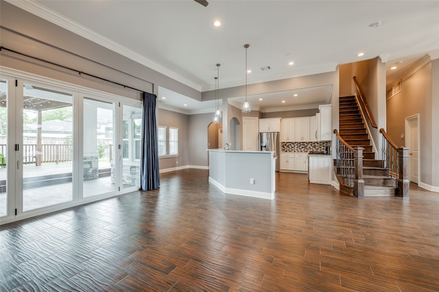 unfurnished living room featuring crown molding, dark hardwood / wood-style flooring, and a healthy amount of sunlight