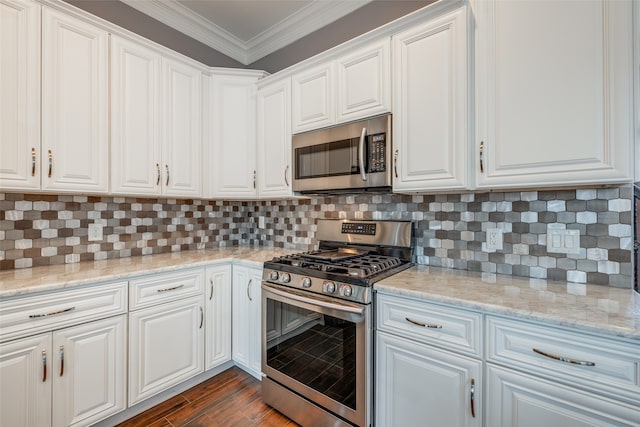 kitchen featuring decorative backsplash, stainless steel appliances, white cabinetry, and dark hardwood / wood-style floors