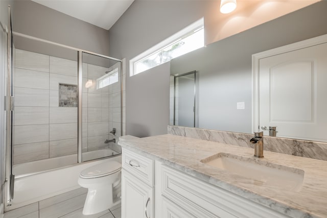 full bathroom with tile patterned flooring, enclosed tub / shower combo, vanity, and toilet