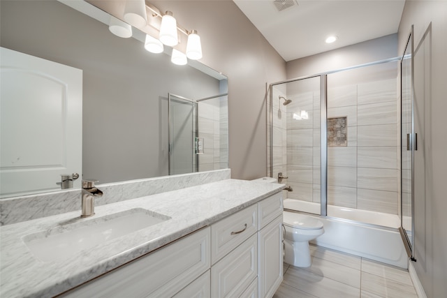 full bathroom featuring tile patterned floors, toilet, vanity, and enclosed tub / shower combo