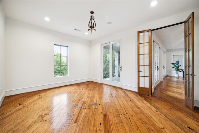 unfurnished room with light hardwood / wood-style floors and french doors