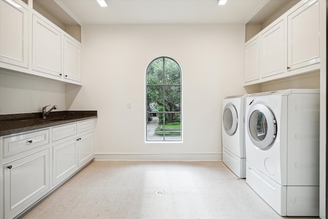 laundry area featuring independent washer and dryer, sink, and cabinets