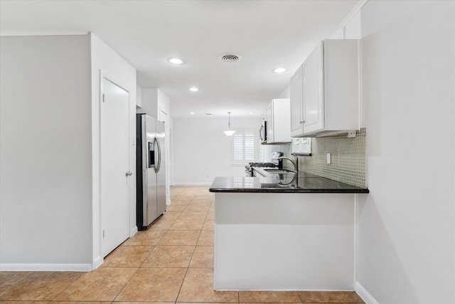 kitchen with backsplash, light tile patterned floors, stainless steel appliances, white cabinetry, and kitchen peninsula