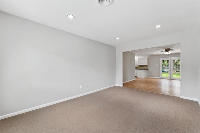 empty room with light colored carpet, french doors, and ceiling fan