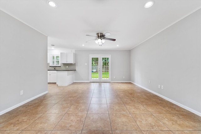 unfurnished living room featuring ceiling fan, light tile patterned flooring, and crown molding