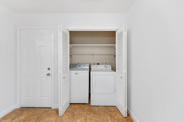 laundry area with washer and clothes dryer and light tile patterned flooring