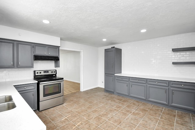 kitchen featuring backsplash, stainless steel electric range, a textured ceiling, light tile patterned floors, and gray cabinets