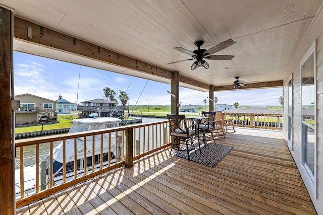 deck with a water view, a residential view, and a ceiling fan