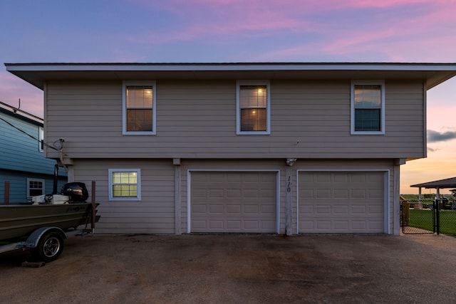 view of front of house featuring a garage, driveway, and fence