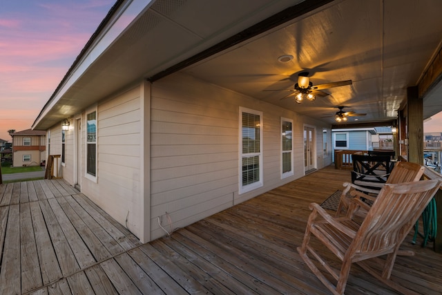 deck at dusk featuring ceiling fan