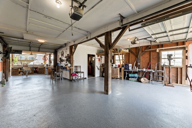 garage featuring a workshop area, freestanding refrigerator, and a garage door opener