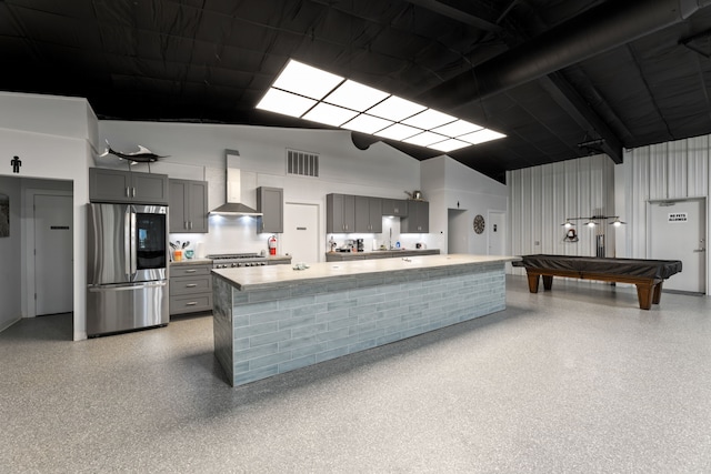 kitchen featuring wall chimney exhaust hood, appliances with stainless steel finishes, gray cabinets, light countertops, and light speckled floor