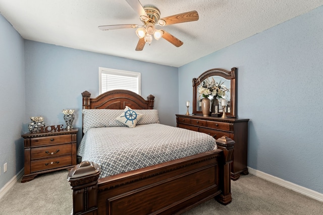 bedroom with ceiling fan, baseboards, a textured ceiling, and light colored carpet