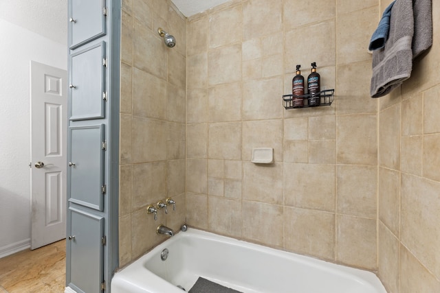 bathroom featuring tub / shower combination and baseboards