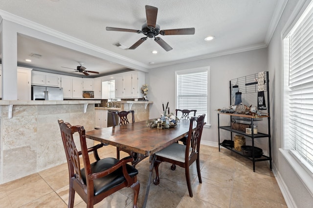 dining space featuring ornamental molding, visible vents, and plenty of natural light