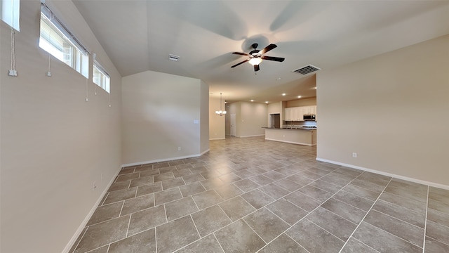 spare room with ceiling fan with notable chandelier and light tile patterned floors