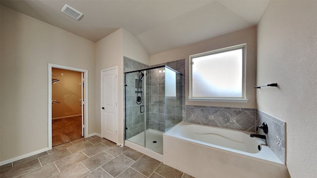 full bath featuring a walk in closet, a garden tub, visible vents, a shower stall, and baseboards