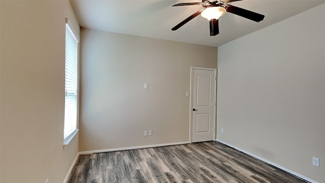 unfurnished room featuring a healthy amount of sunlight, a ceiling fan, baseboards, and wood finished floors