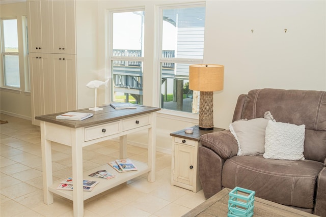 living area featuring light tile patterned floors and baseboards