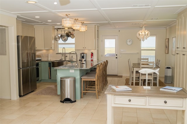kitchen with freestanding refrigerator, a kitchen island, and hanging light fixtures