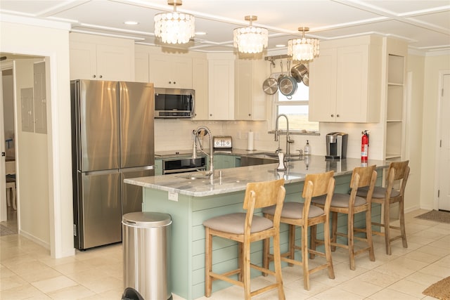 kitchen featuring white cabinets, stainless steel appliances, sink, and a kitchen bar