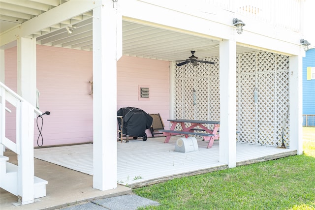 wooden terrace with a yard, ceiling fan, and grilling area