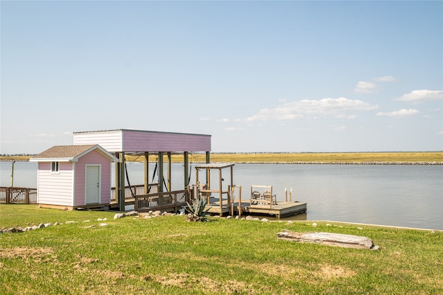 view of dock featuring a lawn and a water view