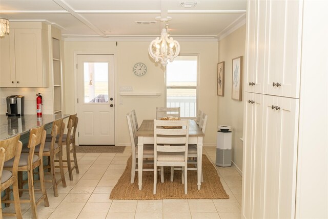 dining space with ornamental molding, a chandelier, baseboards, and light tile patterned floors
