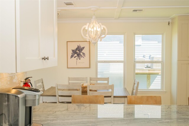 dining room with coffered ceiling and a chandelier