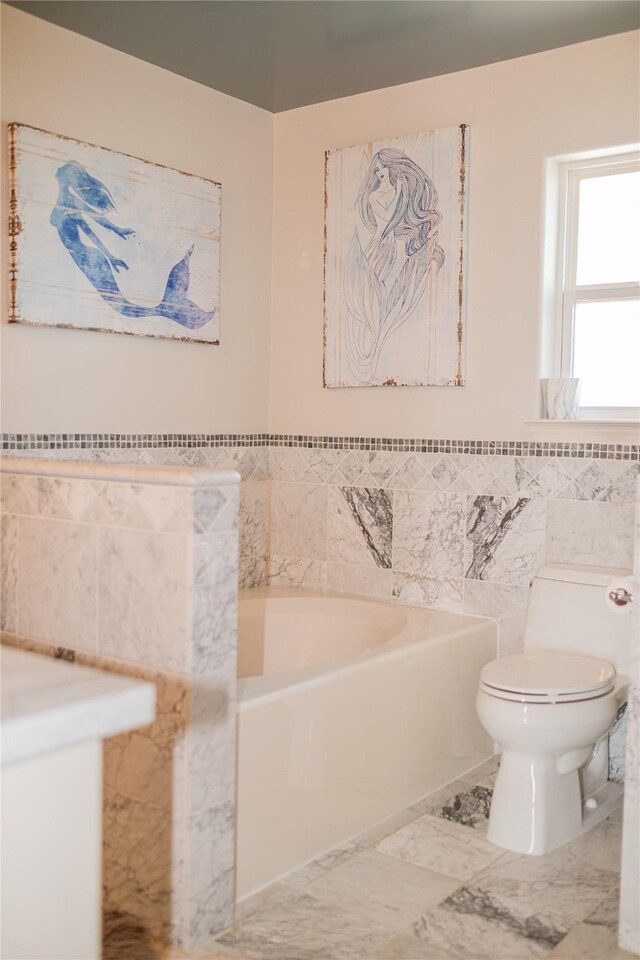 bathroom with toilet, tile walls, and a bath